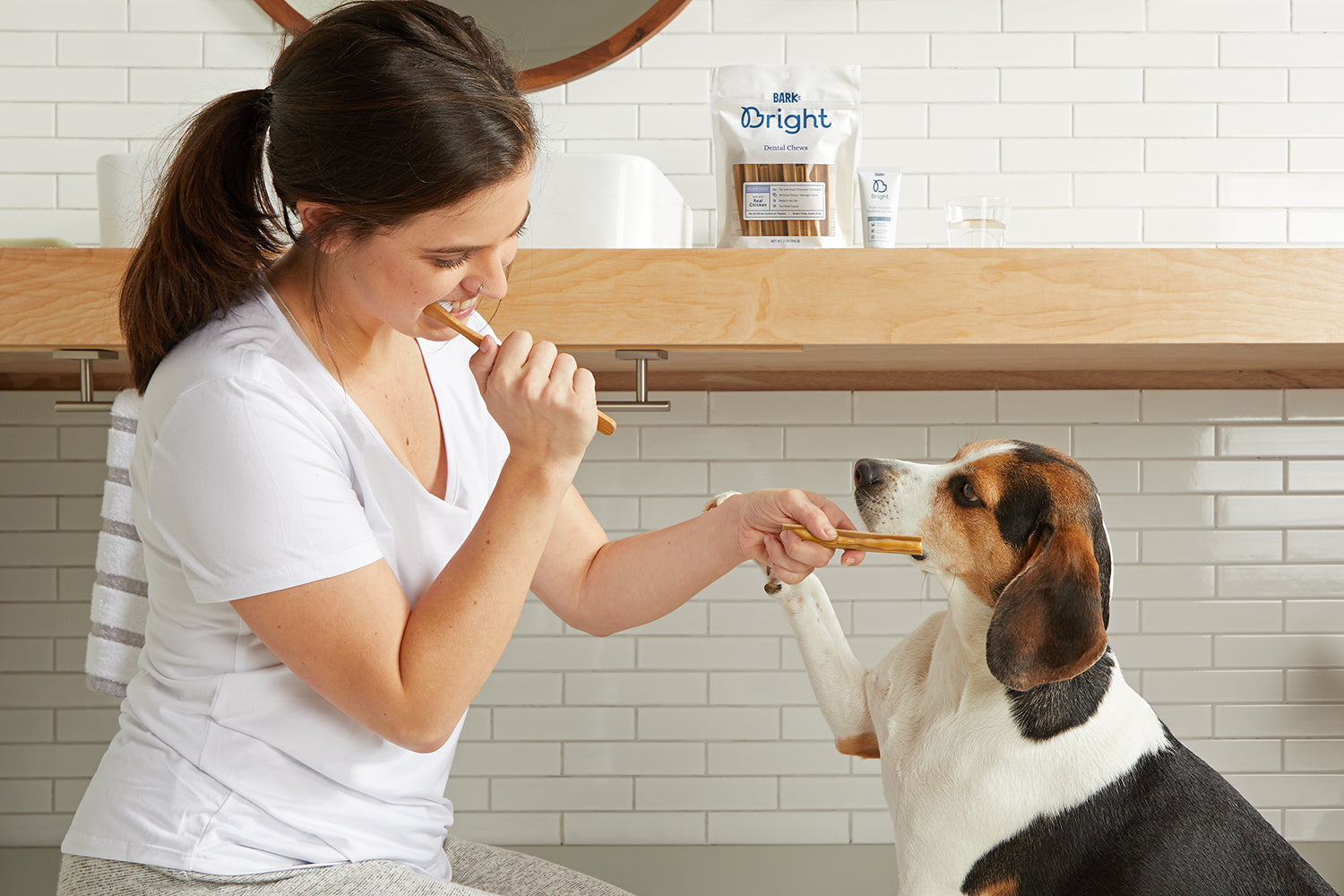woman brushing teeth with dog