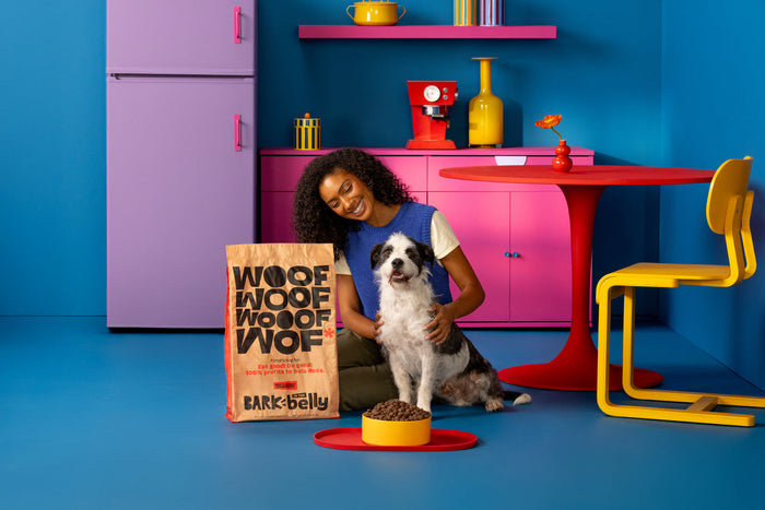 dog and human next to food bag